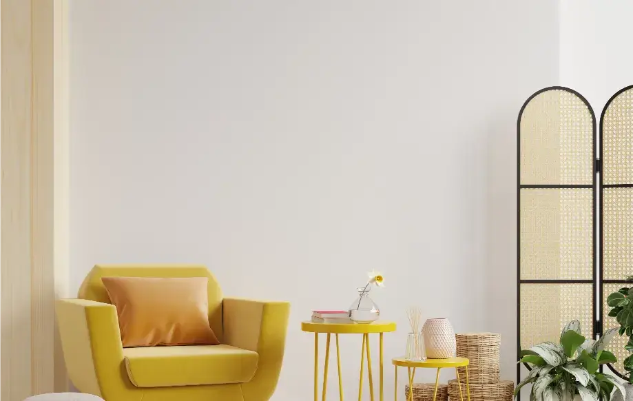 salon, żółty fotel z poduszką, dwa żółte stoliki, kwiaty
